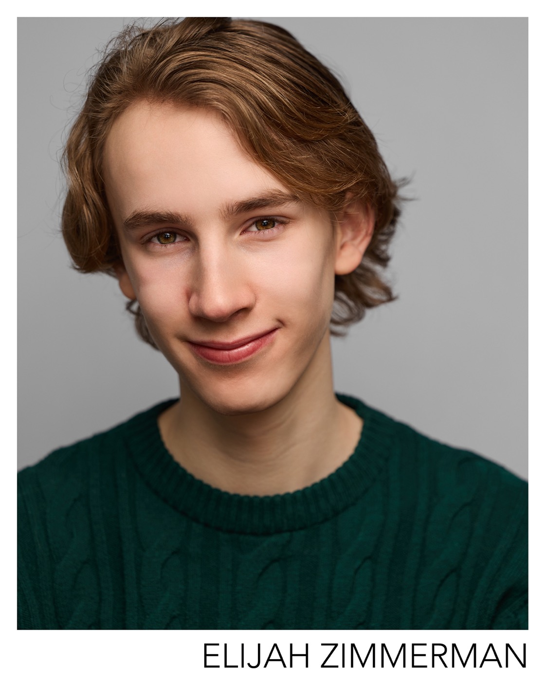 Elijah Zimmerman headshot — green sweater